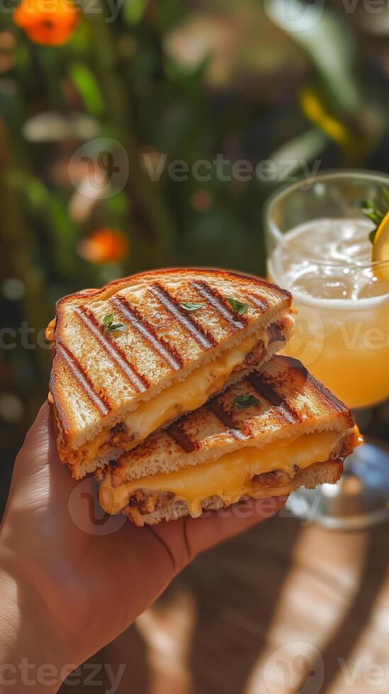Delicious grilled cheese sandwich served with a refreshing drink in a vibrant outdoor setting photo