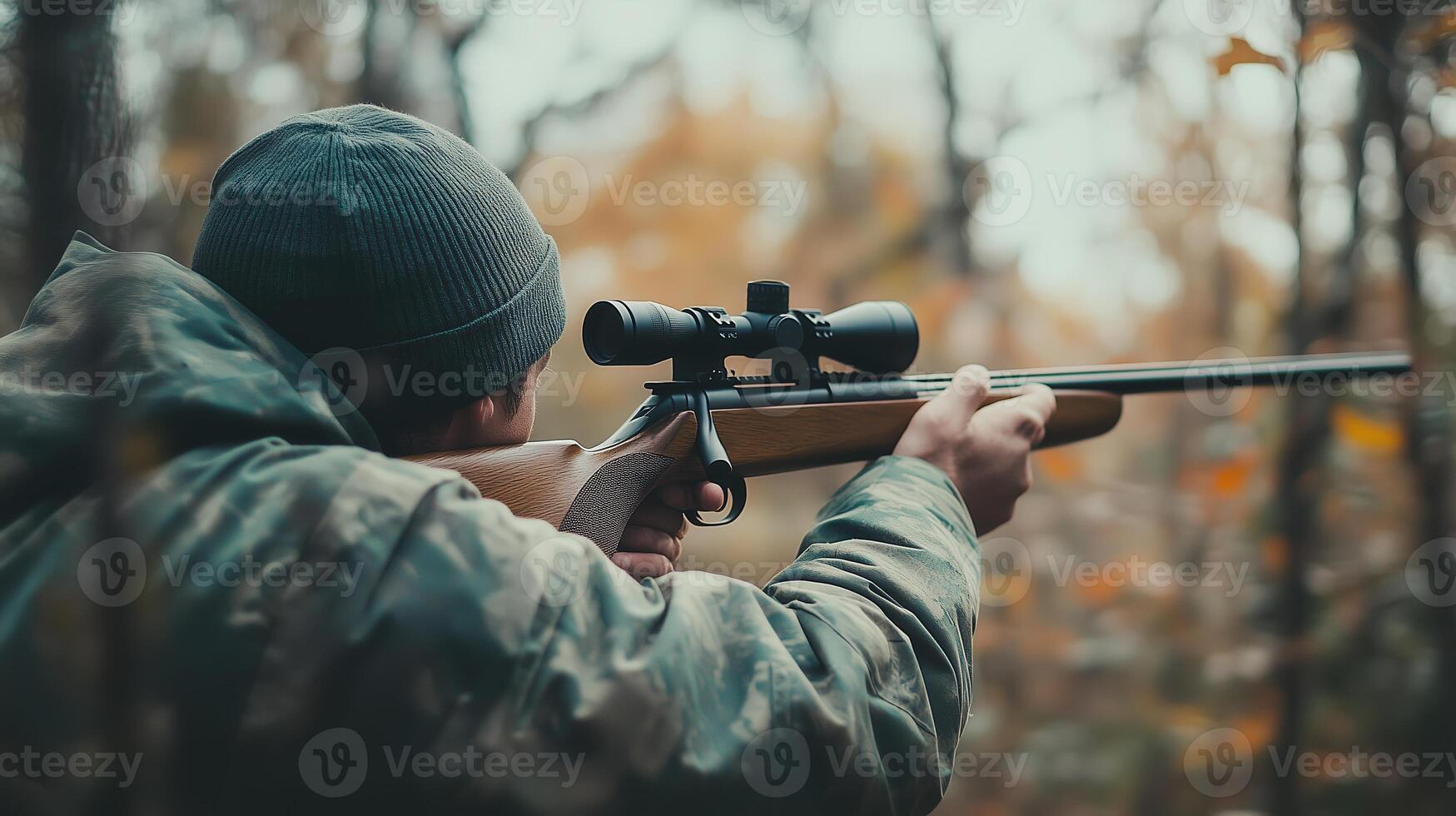 Hunter aiming a rifle in a dense forest during autumn, focused on a target amidst colorful foliage photo
