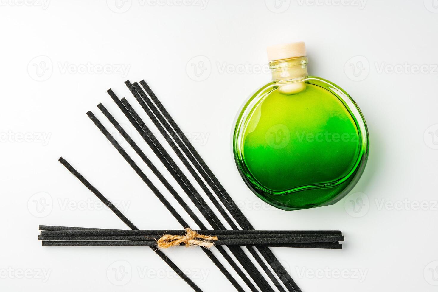 A minimalist display of essential oil and black diffuser sticks on a clean white background photo