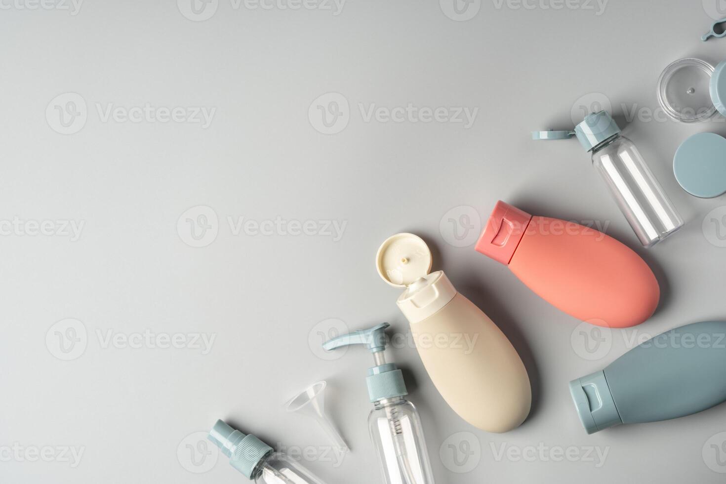 Collection of various reusable cosmetic containers arranged on a light gray background photo
