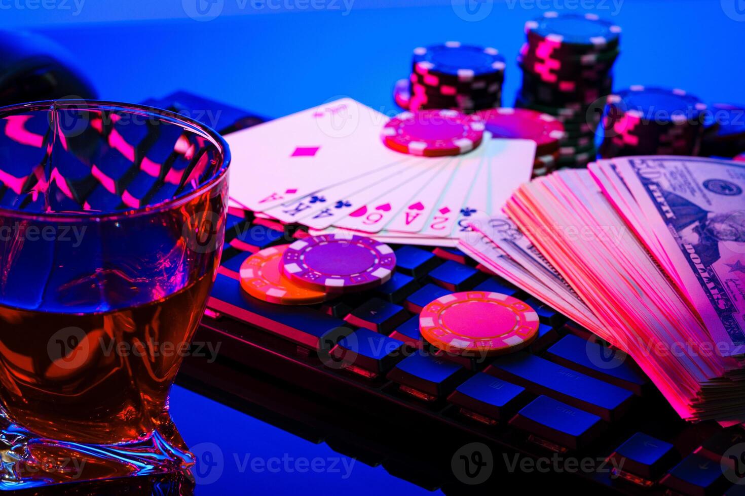 Game chips and cash on a dimly lit keyboard during an exciting gaming night at home photo