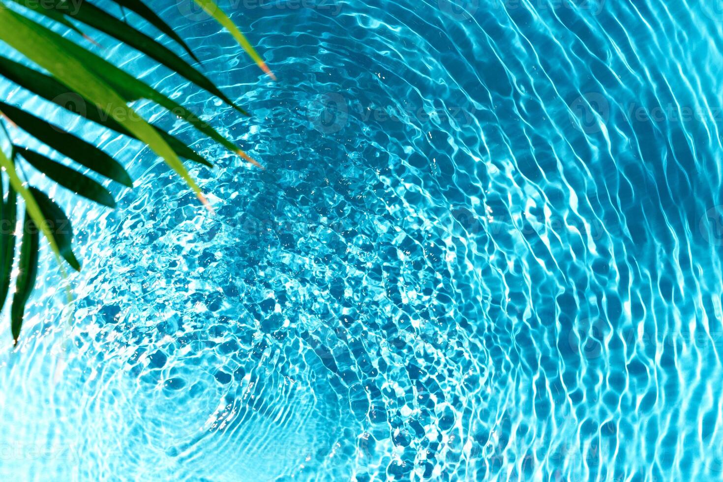 Clear turquoise pool water glistens under sunlight with gentle ripples photo