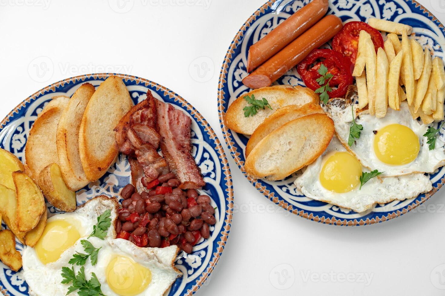 Two plates of a hearty breakfast served on decorative bowls photo