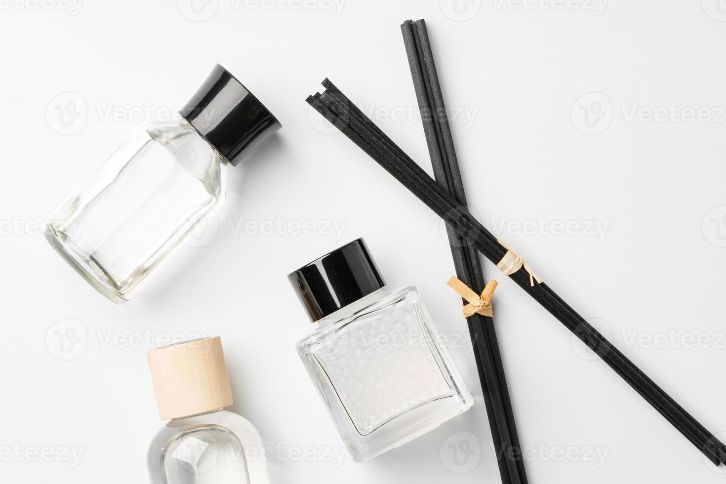 Elegant arrangement of essential oil diffusers with reeds and glass bottles on a minimalist surface photo