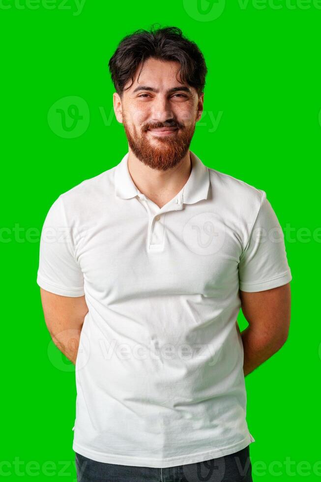 A smiling young man with a beard poses against a bright green background photo