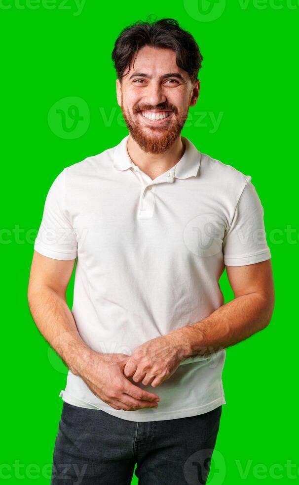 A smiling young man with a beard poses against a bright green background photo