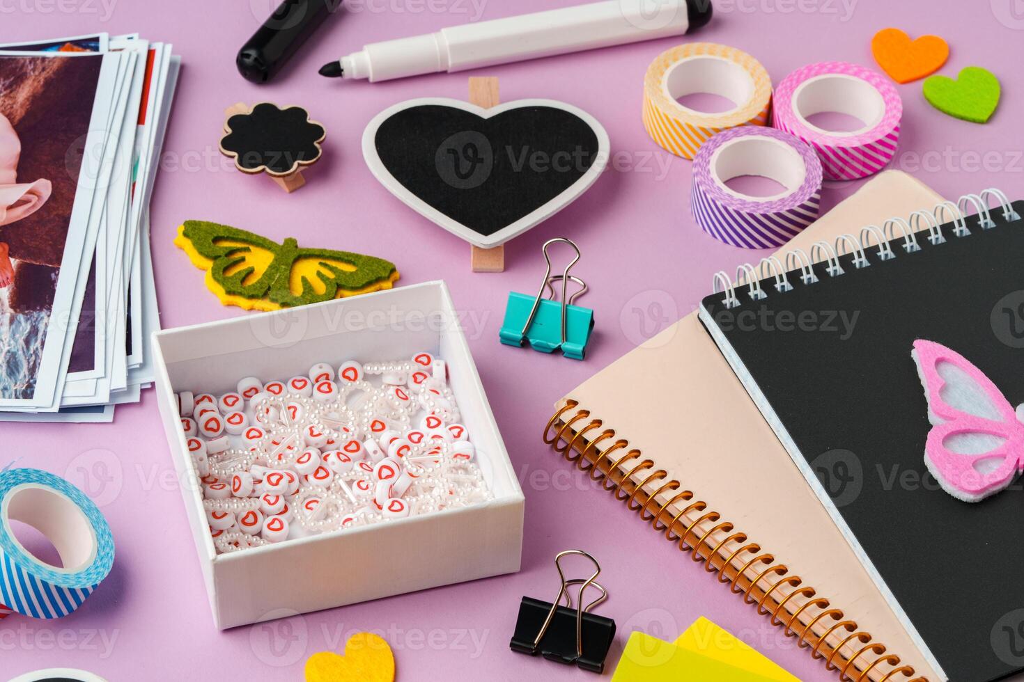 Crafting supplies for scrapbooking arranged on a purple surface photo