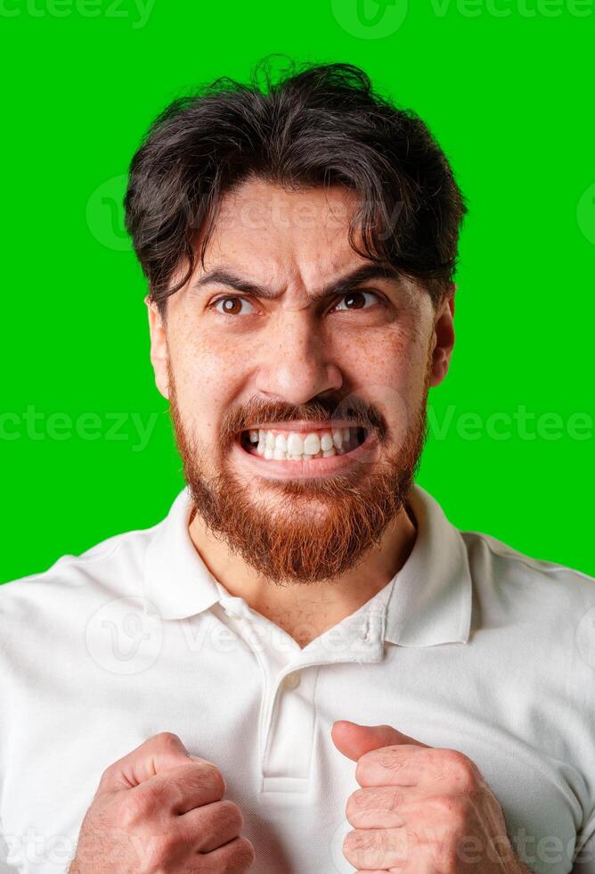 A man expresses intense frustration with a furious gesture against a bright green backdrop photo