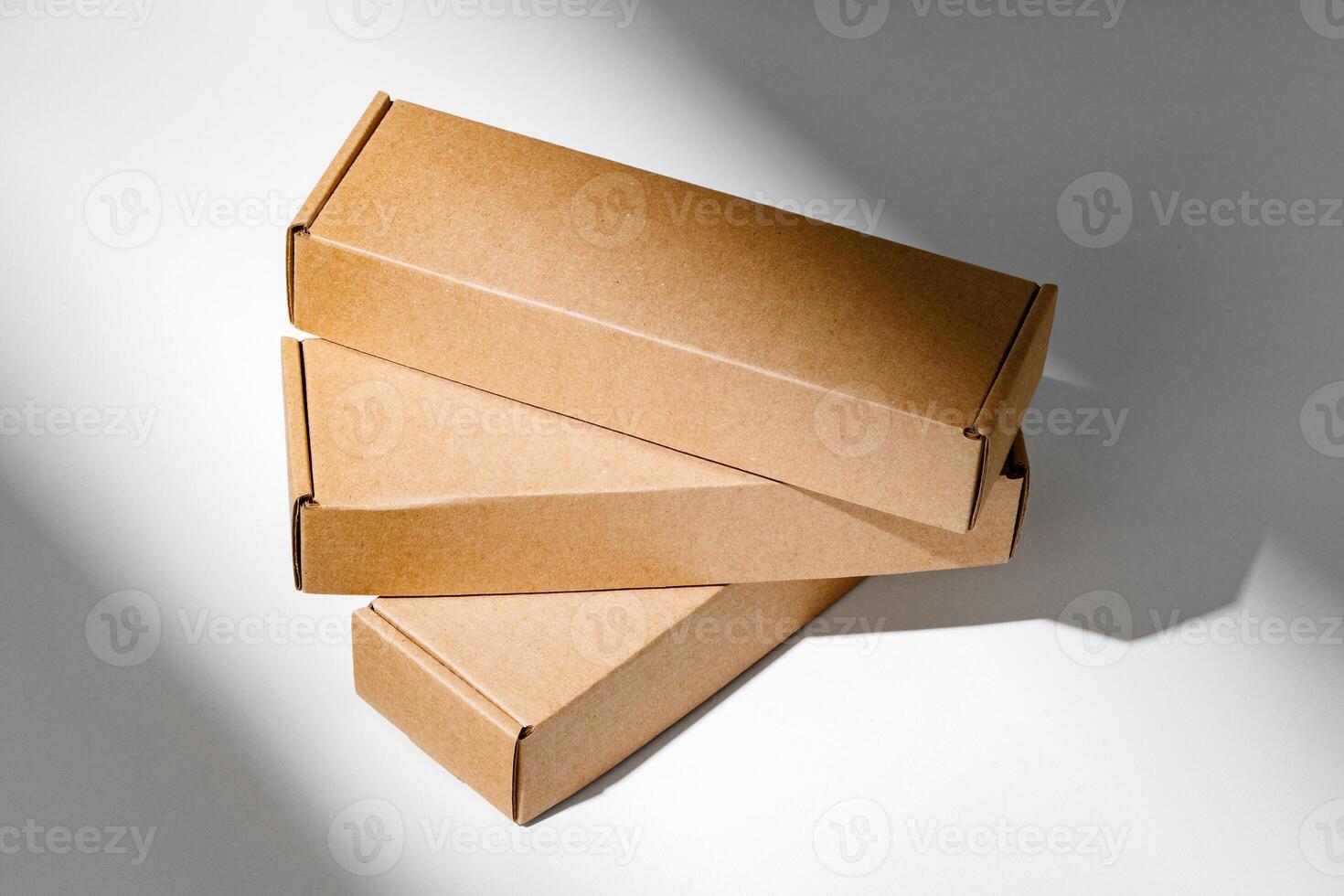 Freshly packed cardboard boxes resting on a white surface, illuminated by soft natural light photo
