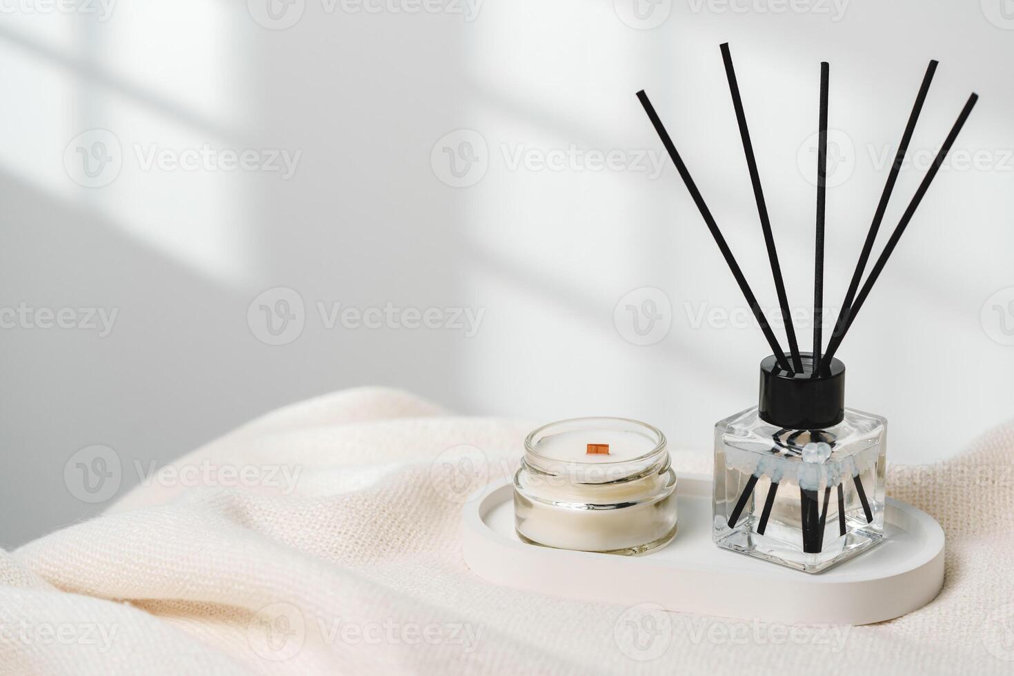 Elegant Aroma Diffuser With Reed Sticks And Scented Candle On White Tablecloth photo