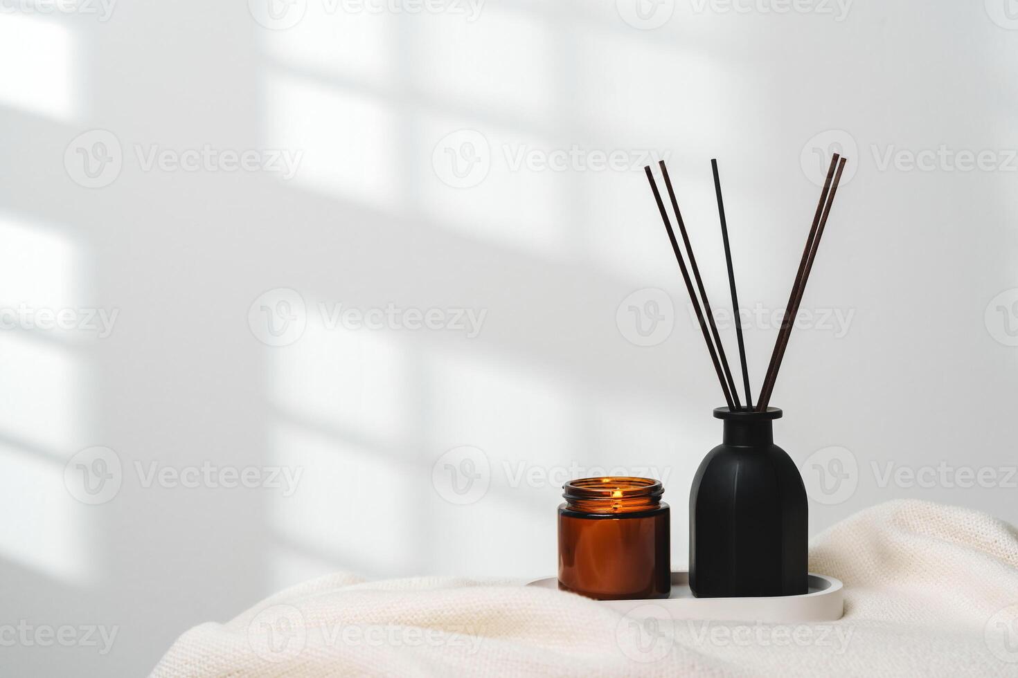 Elegant Aroma Diffuser With Reed Sticks And Scented Candle On White Tablecloth photo