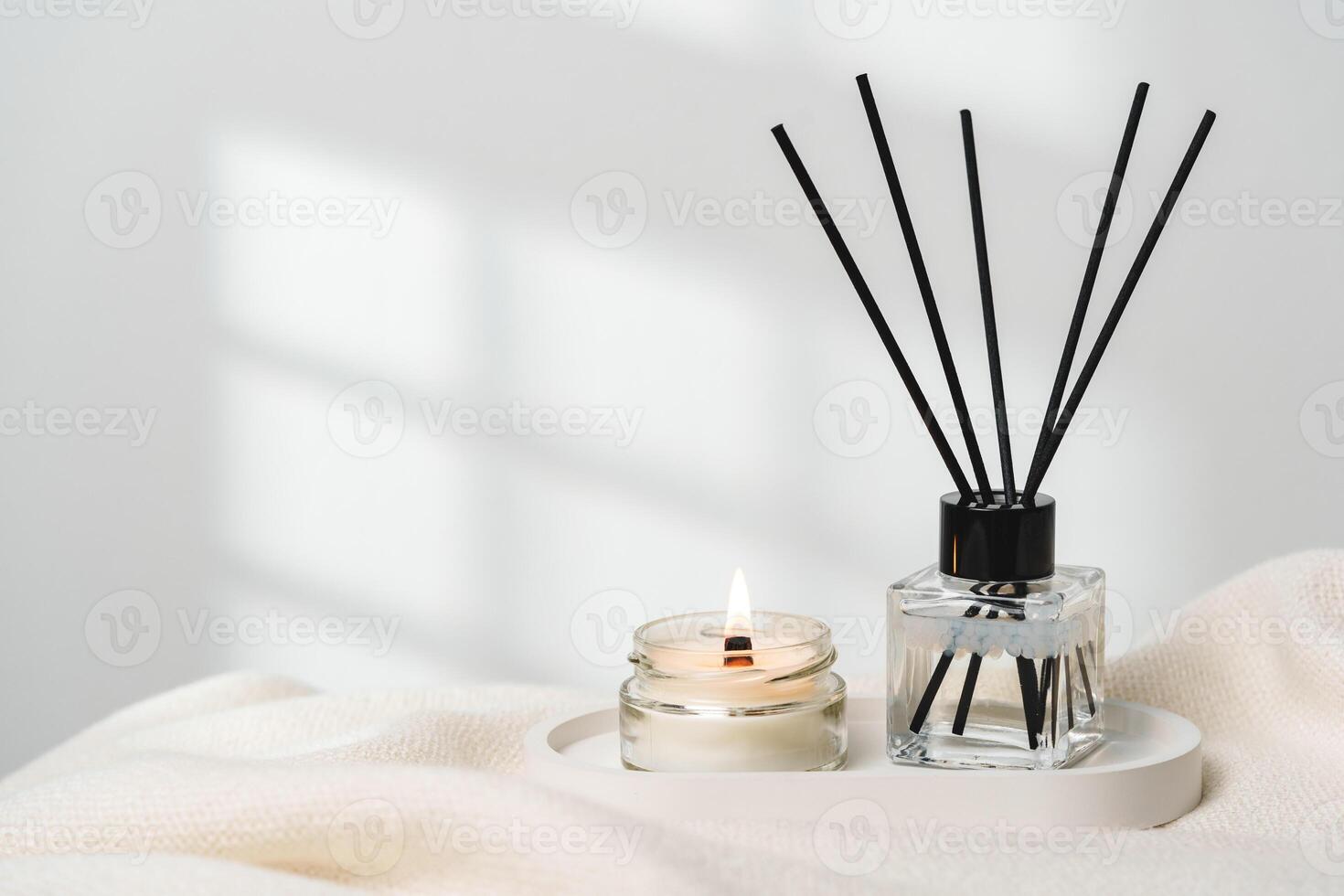 Elegant Aroma Diffuser With Reed Sticks And Scented Candle On White Tablecloth photo