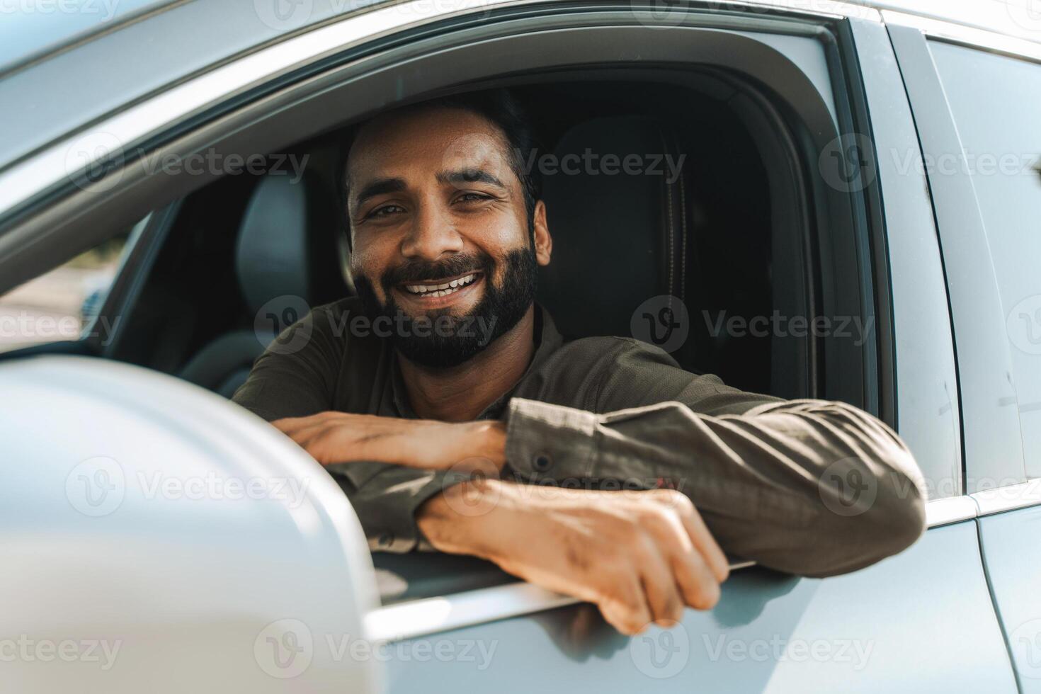 Happy driver, Indian man smiling while sitting inside his new car photo