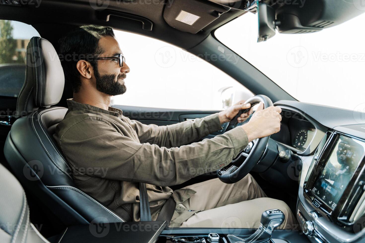 Happy Indian businessman driving modern car in the city photo
