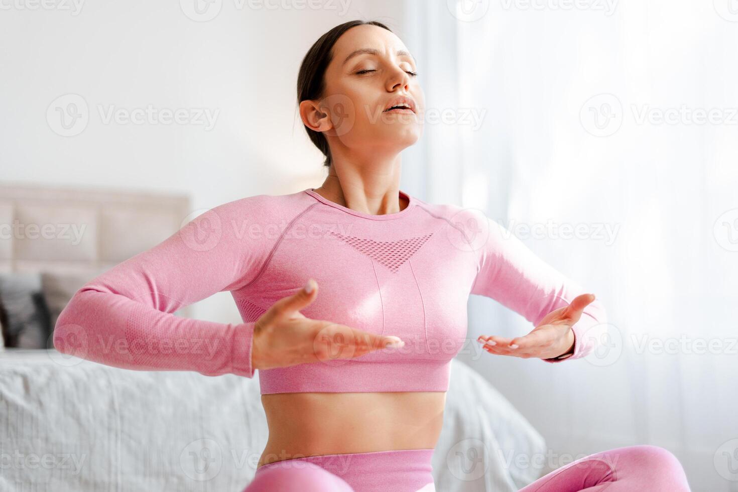 Front view full body portrait of relaxed woman doing yoga exercise in morning home photo