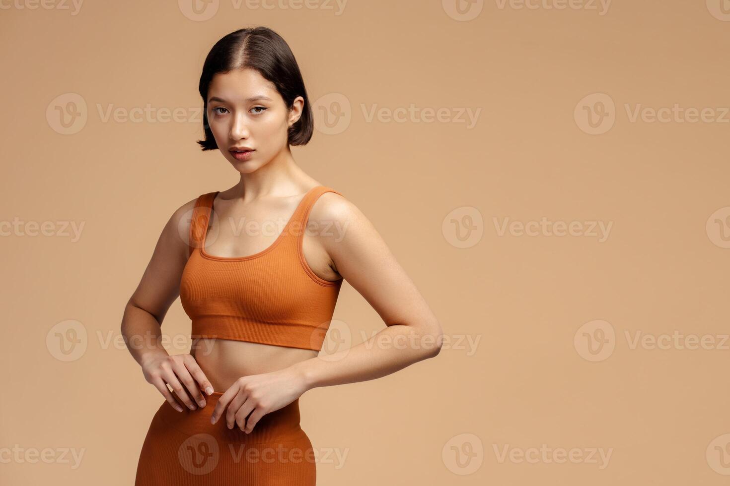 Serious attractive sports woman wearing fitness uniform, posing for picture isolated photo
