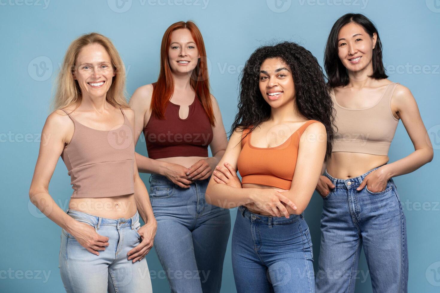 Diverse group of women smiling and posing confidently in jeans and tank tops photo