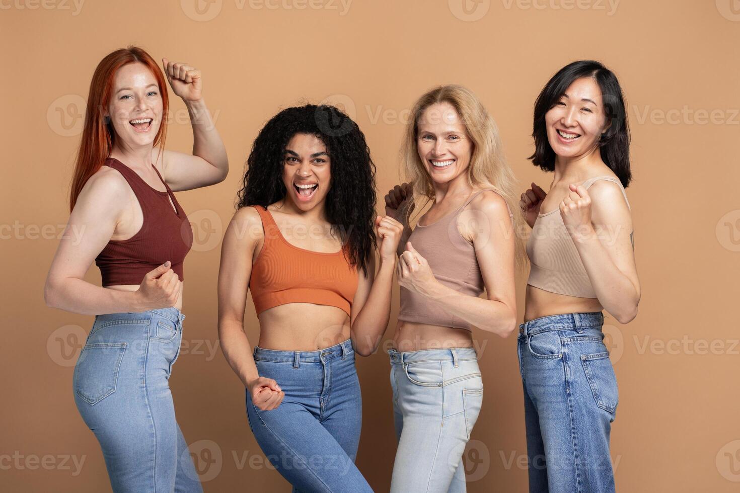 Diverse group of multiracial women wearing stylish tank top celebrating isolated on beige background photo