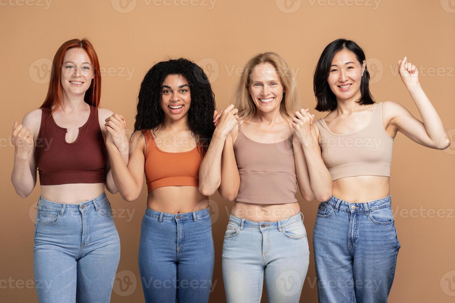 Diverse group of multiracial women wearing stylish tank top celebrating isolated on beige background photo