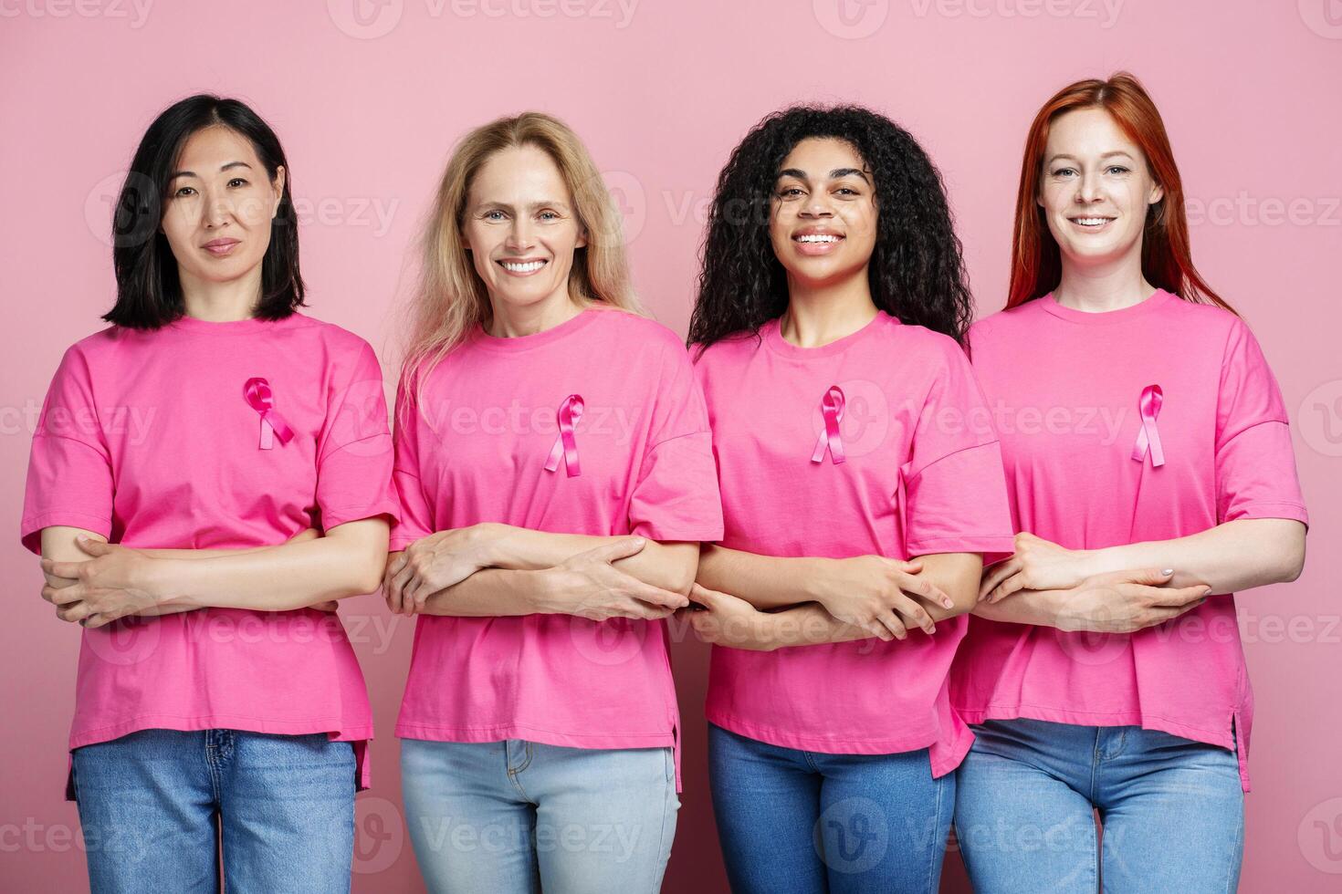 Diverse group of women embracing wearing pink t shirts with pink ribbons photo