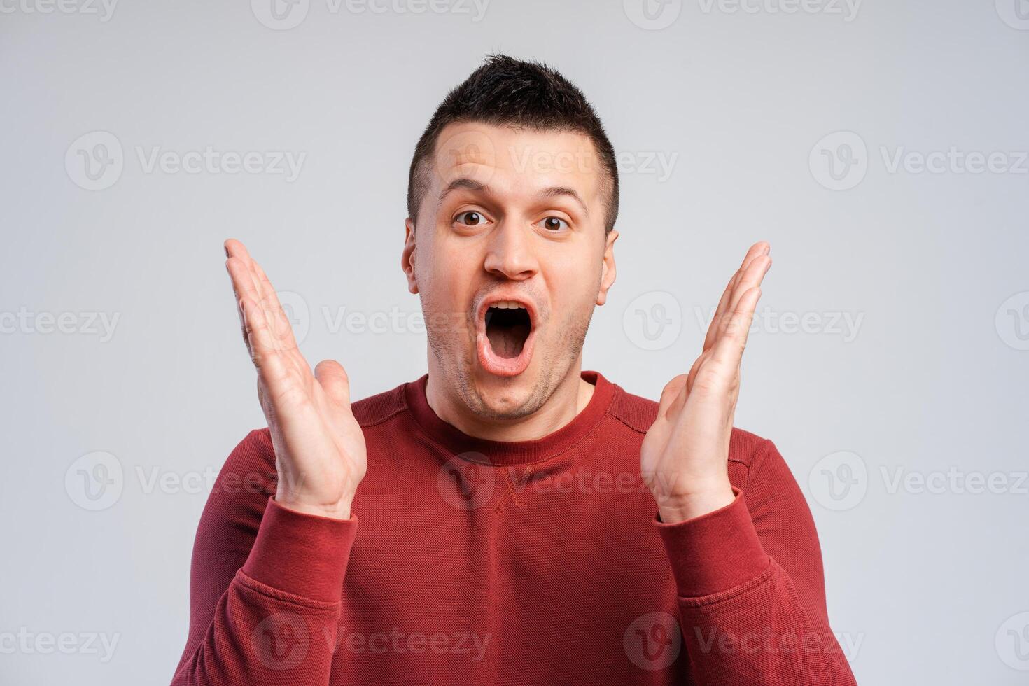 Portrait of an shocked middle aged man amazed for success with arms raised, screaming isolated over gray background. Winner concept. photo