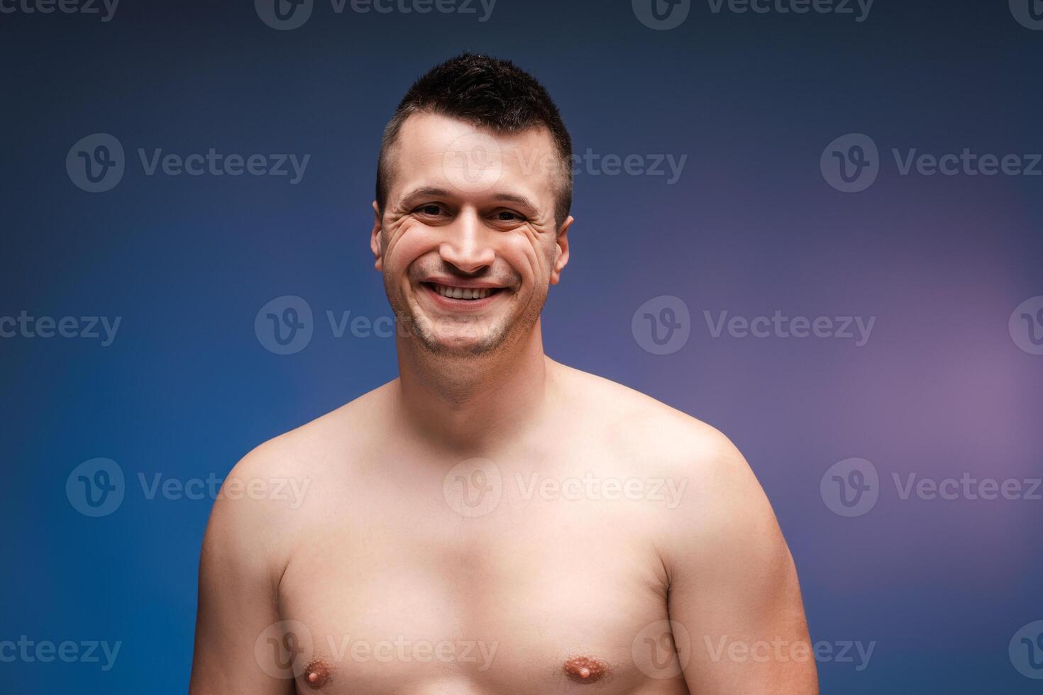 Happy man smiling posing showing torso on blue background photo