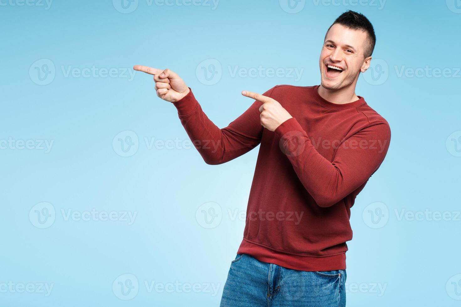 Middle aged smiling man pointing index finger towards copy space for text, logo photo