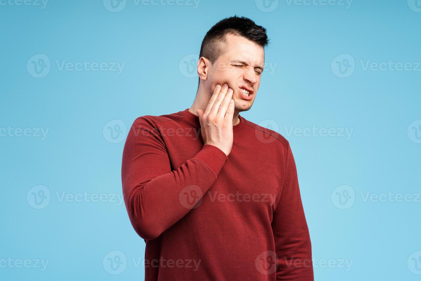 Dental problems. Unhealthy man pressing sore cheek, suffering acute toothache, periodontal disease photo
