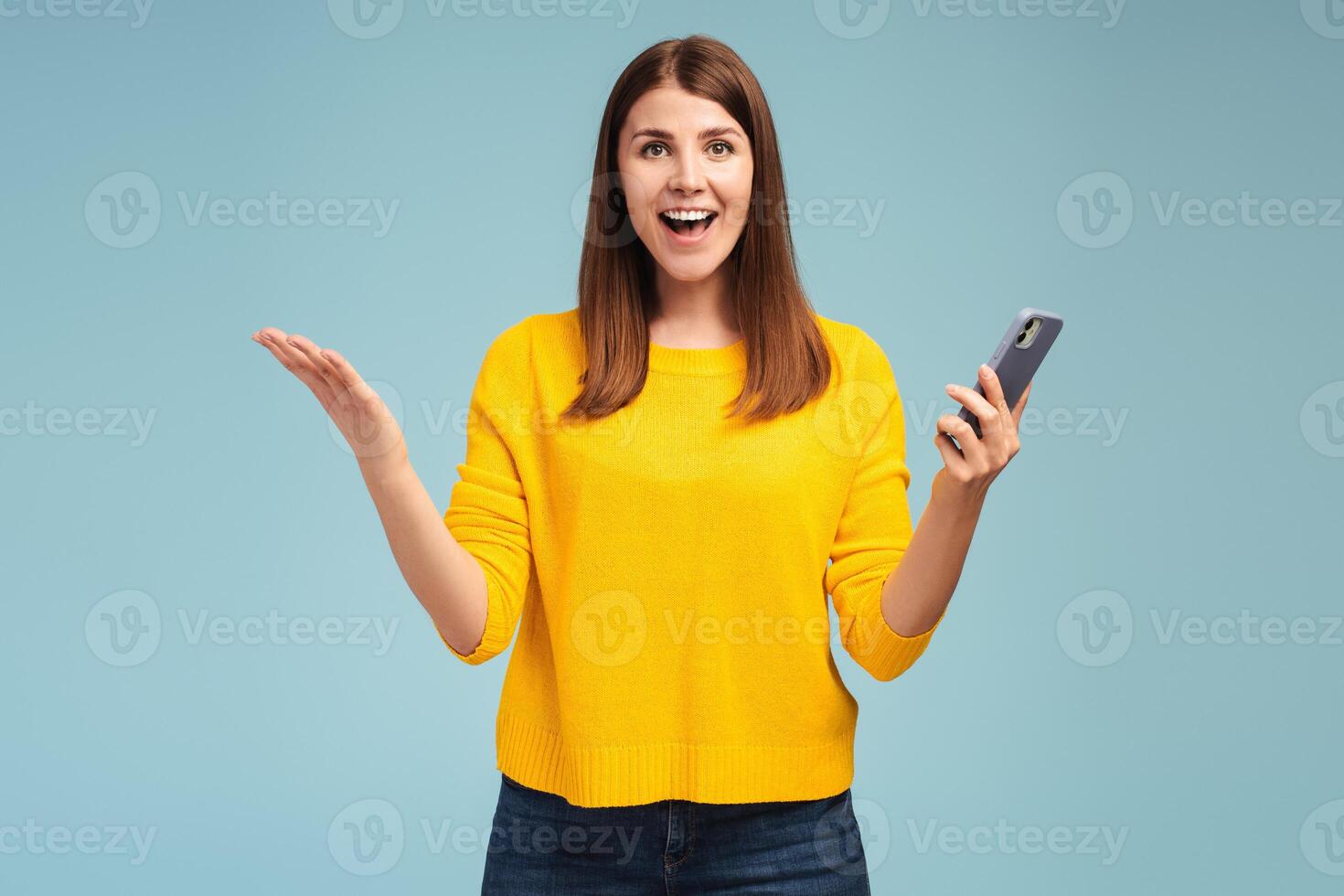 Excited, happy, smiling middle aged woman holding mobile phone, using mobile application photo