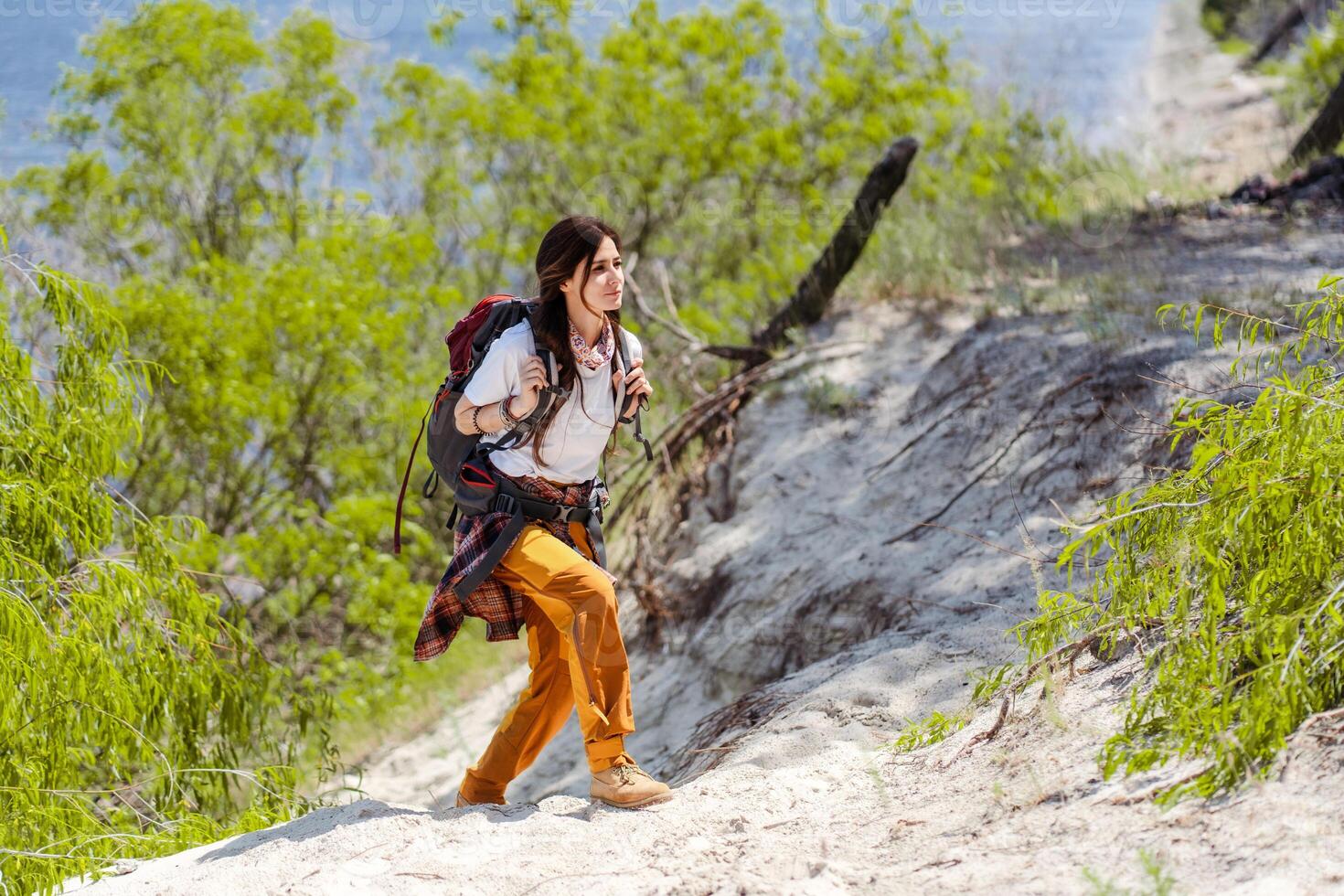 Hiking, smile and woods with woman walking in nature or the wilderness for adventure photo