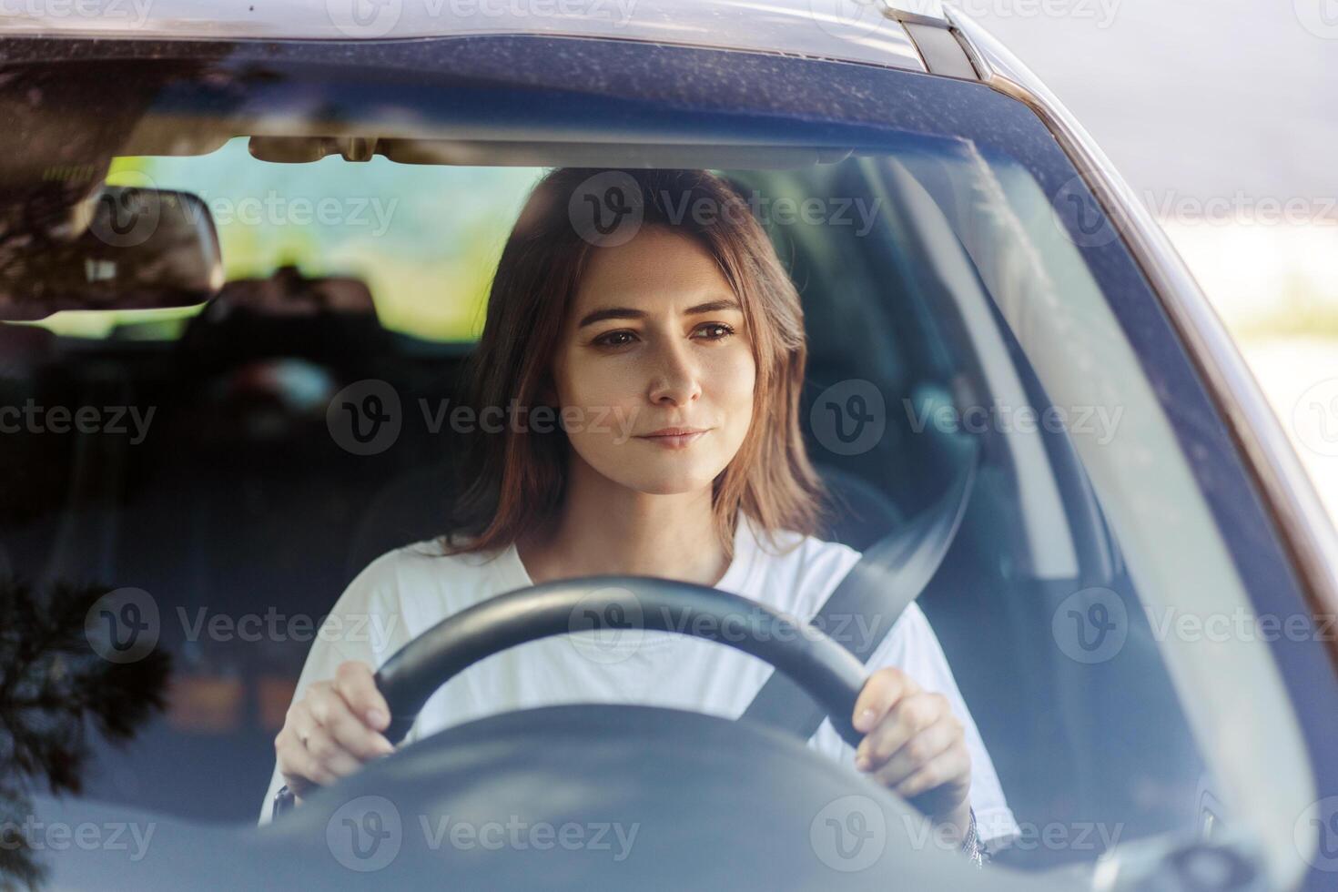 Happy woman driving a car and smiling while enjoying at nature photo