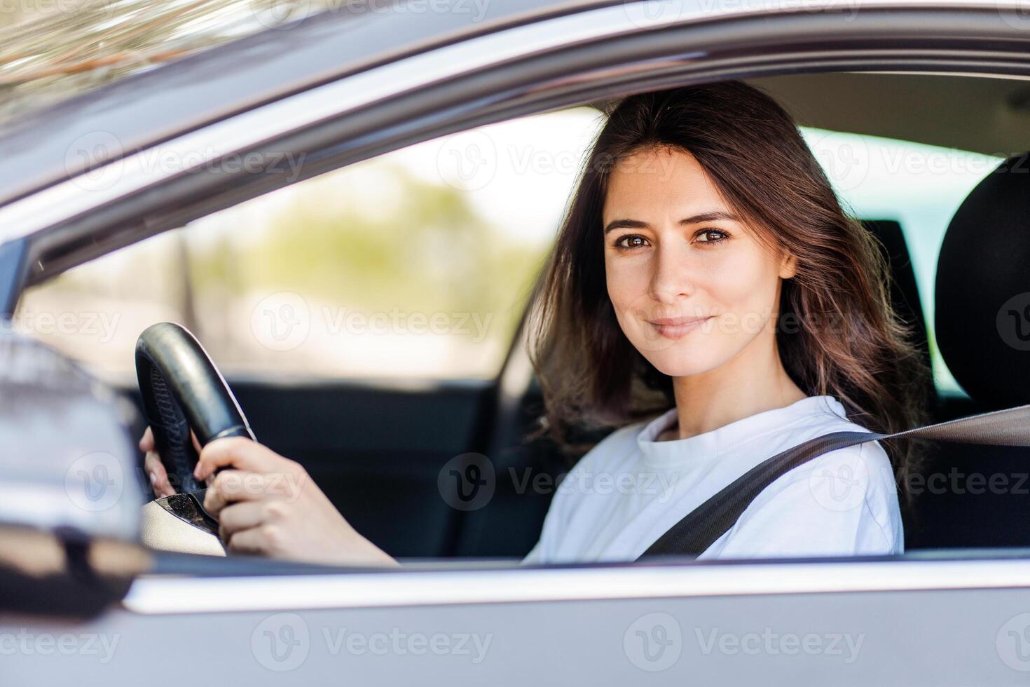 Happy woman driving a car and smiling while enjoying at nature photo