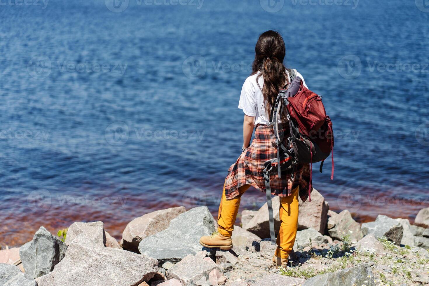 Beautiful woman traveler enjoying autumn hiking along the river photo