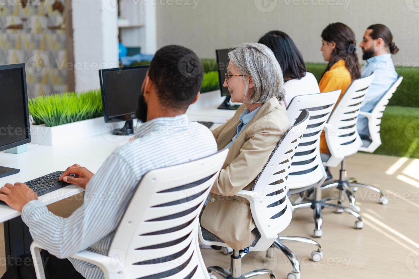 Diverse team of professionals working on computers in modern office photo
