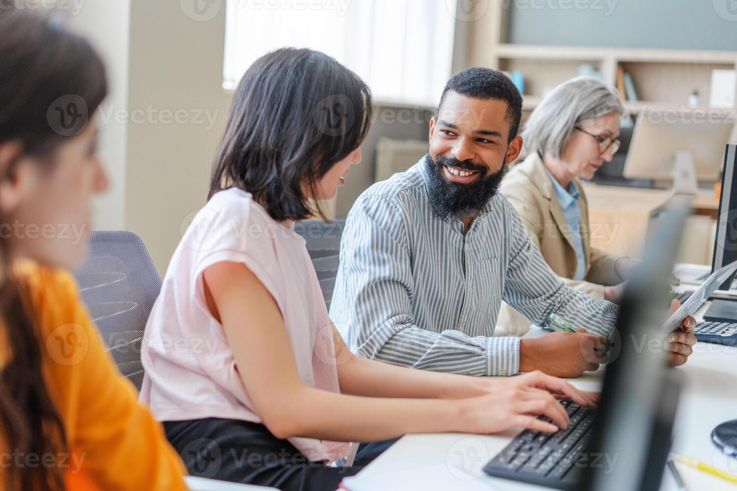 Diverse team of programmers working on computers in modern office photo