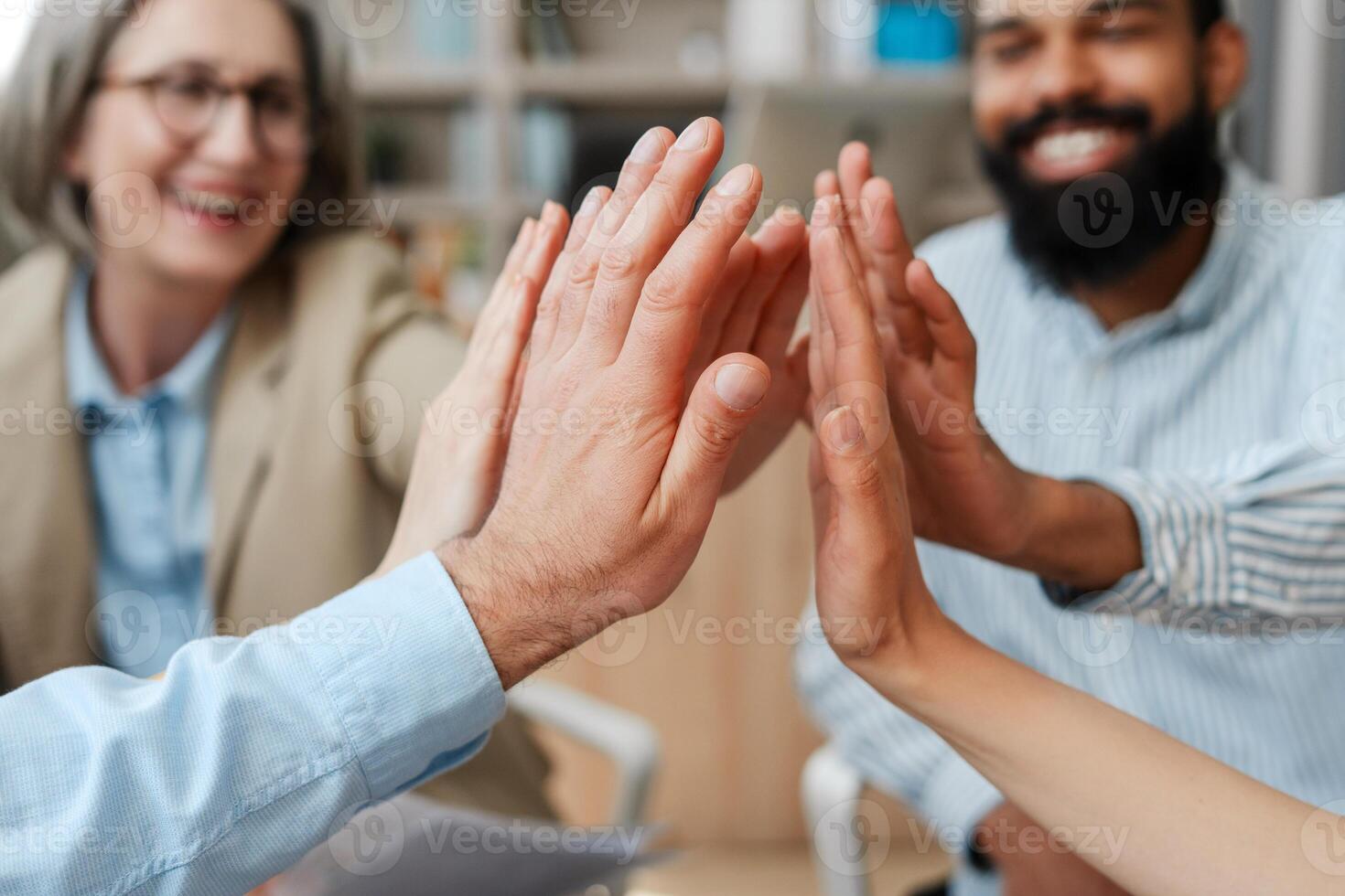 Business people team giving high five together in modern office selective focus photo