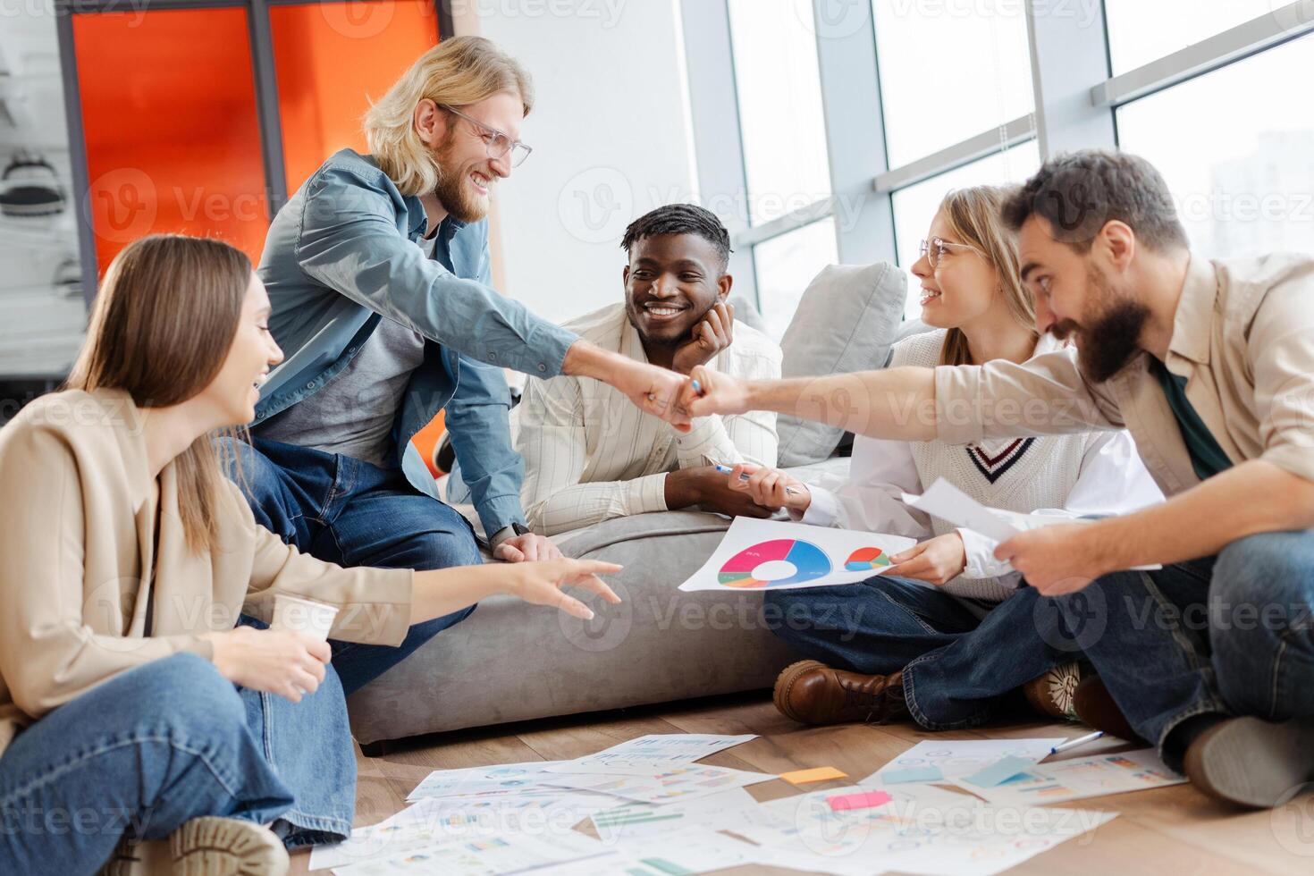Diverse team giving fist bump celebrating successful project photo