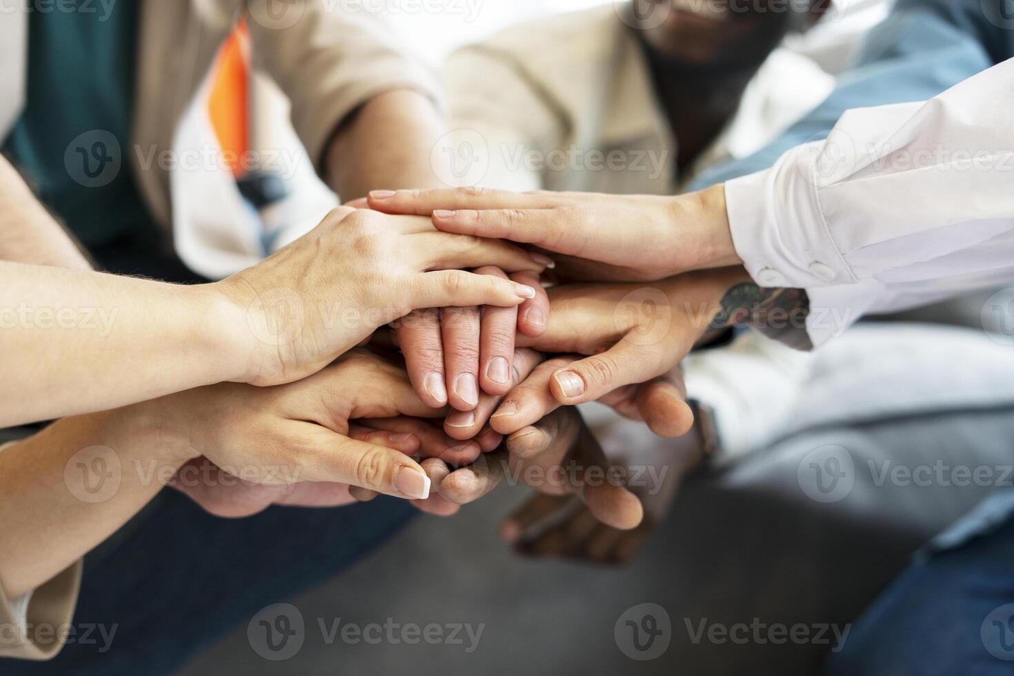Diverse team joining hands showing unity and teamwork photo