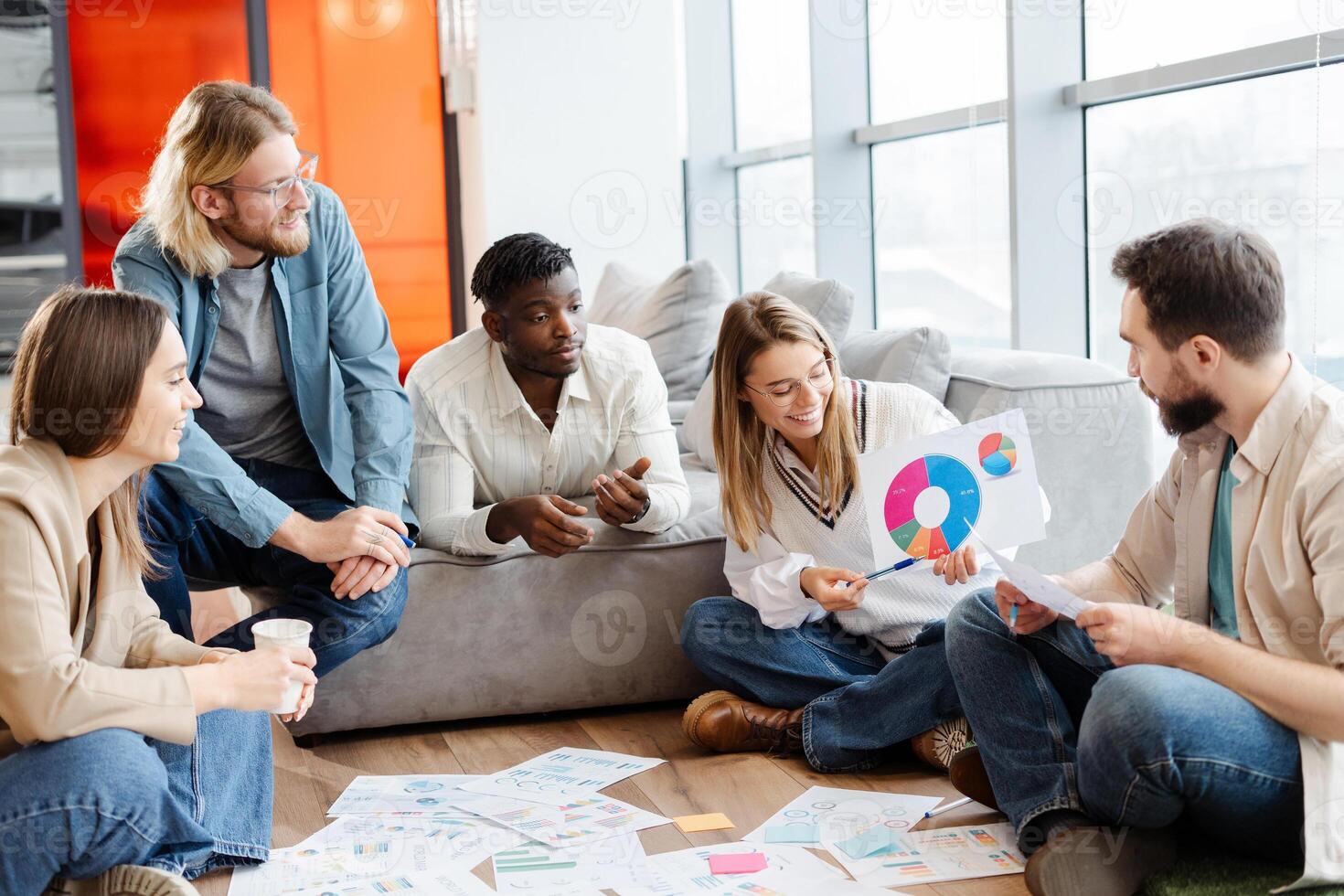 Diverse team of professionals discussing financial charts and graphs during a productive meeting photo