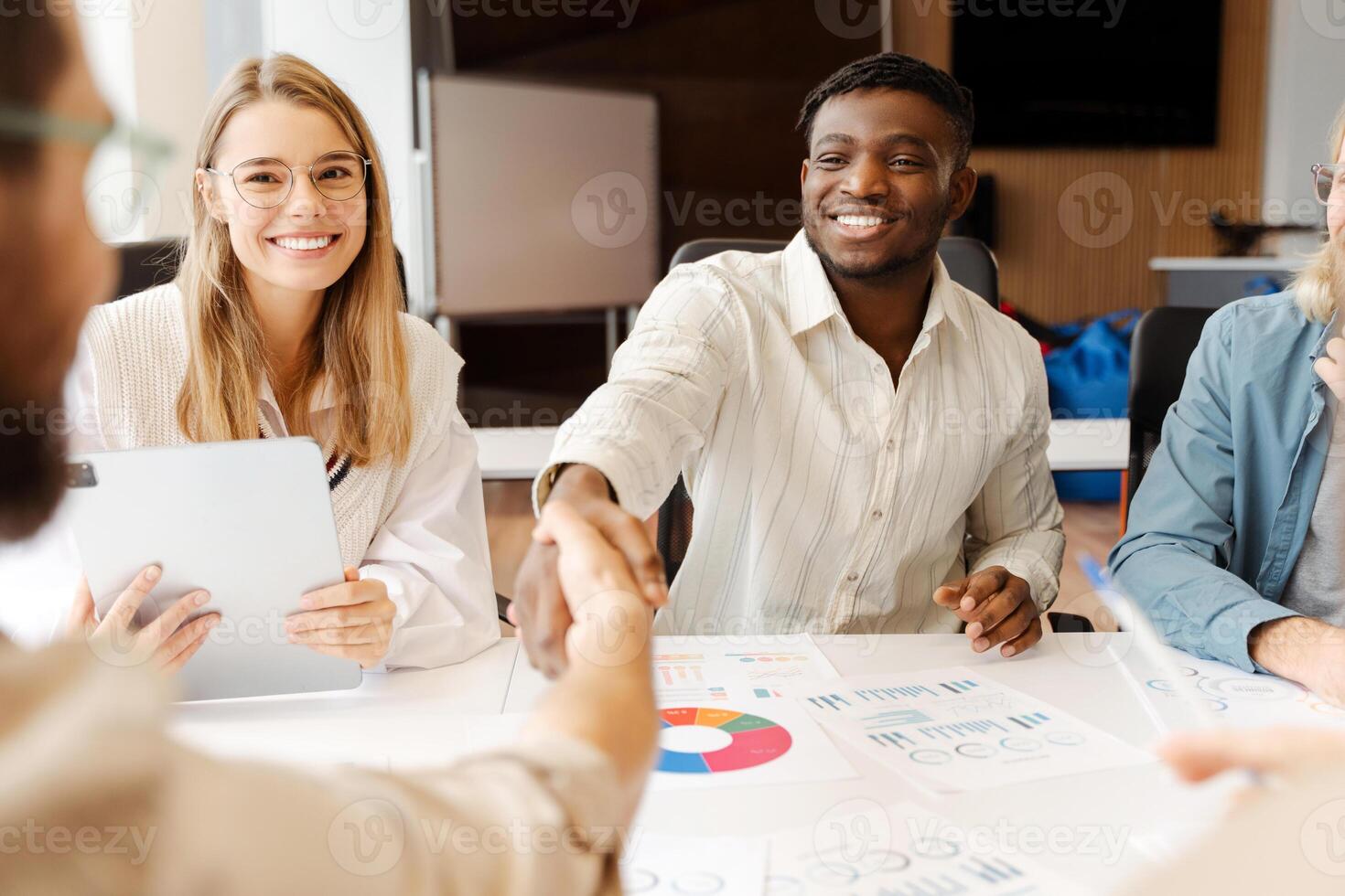 Young business team shaking hands during meeting, contract concept photo
