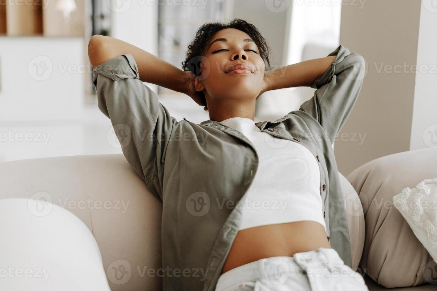 Young woman relaxing on comfortable sofa at home photo