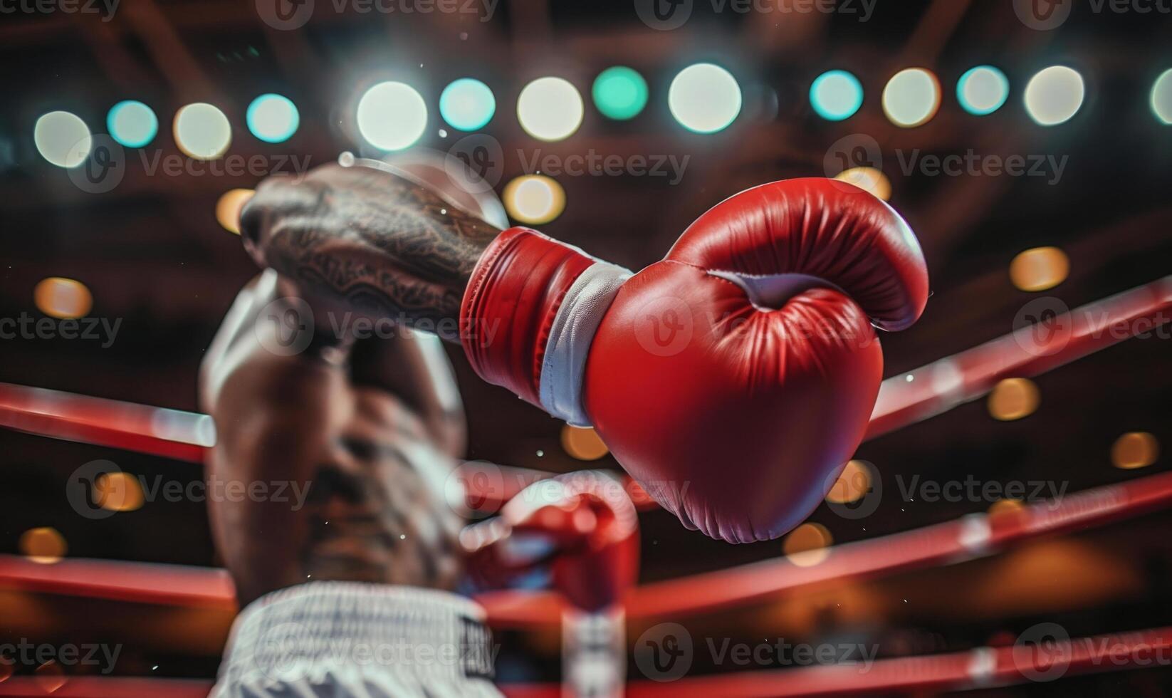 A boxer's gloved hands and body in a fighting stance, with a boxing ring in the background photo