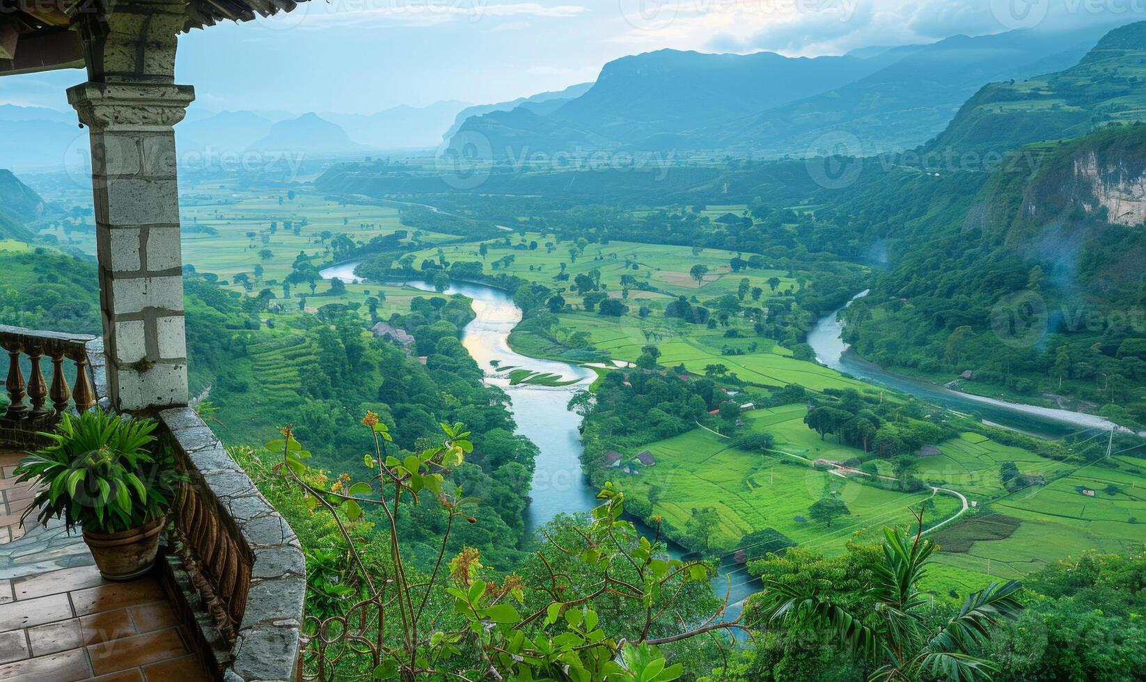 A panoramic view of a winding river through a lush valley, seen from a balcony of a highland retreat photo