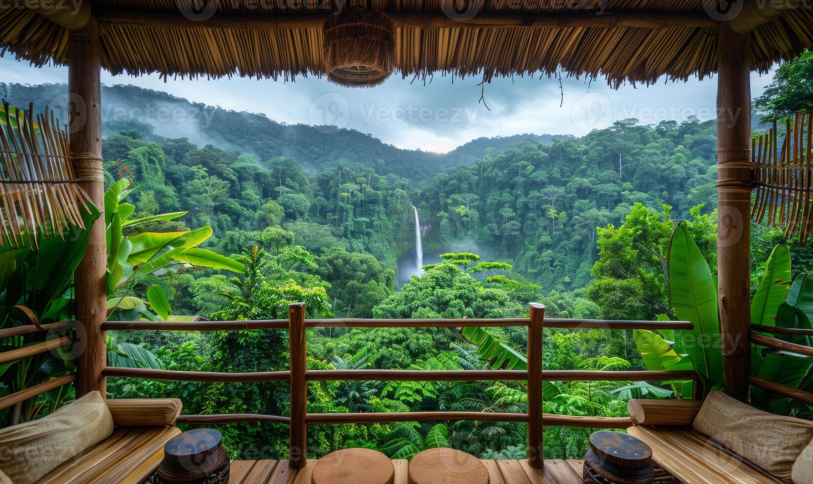 A stunning view of a lush rainforest canopy with a distant waterfall, viewed from a balcony of an eco-lodge photo
