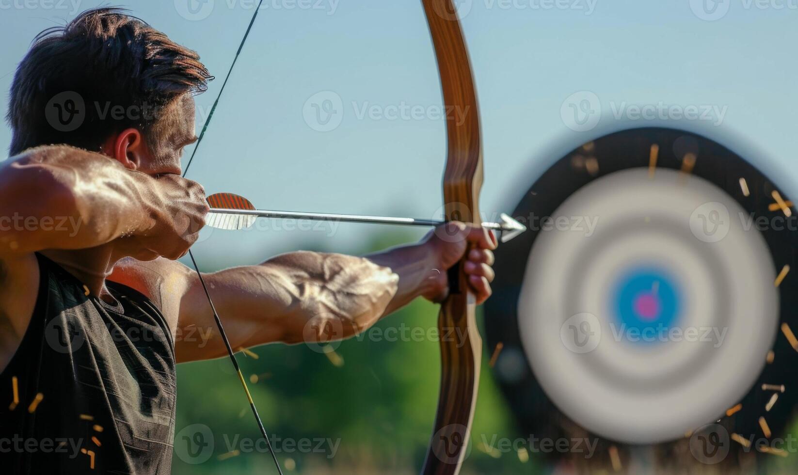 An archer's body aiming a bow, with the target in the background photo