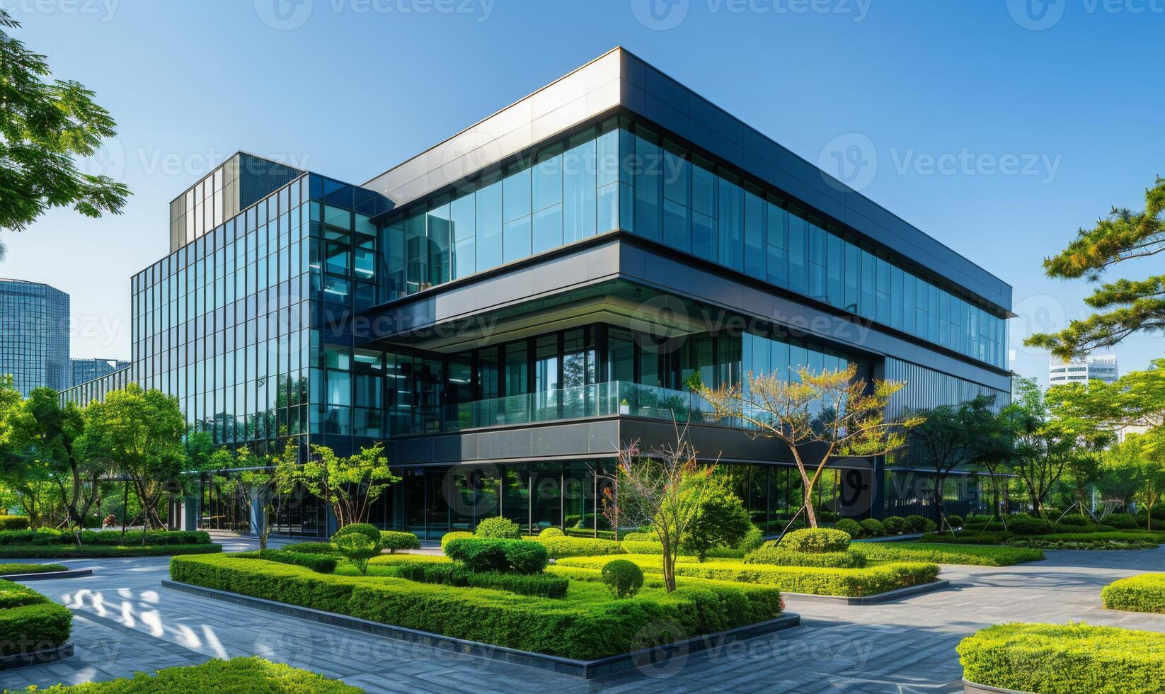 A modern office building with glass windows and green landscaping photo