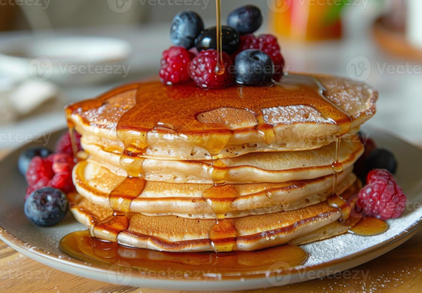 A stack of fluffy pancakes drizzled with maple syrup and topped with fresh berries photo