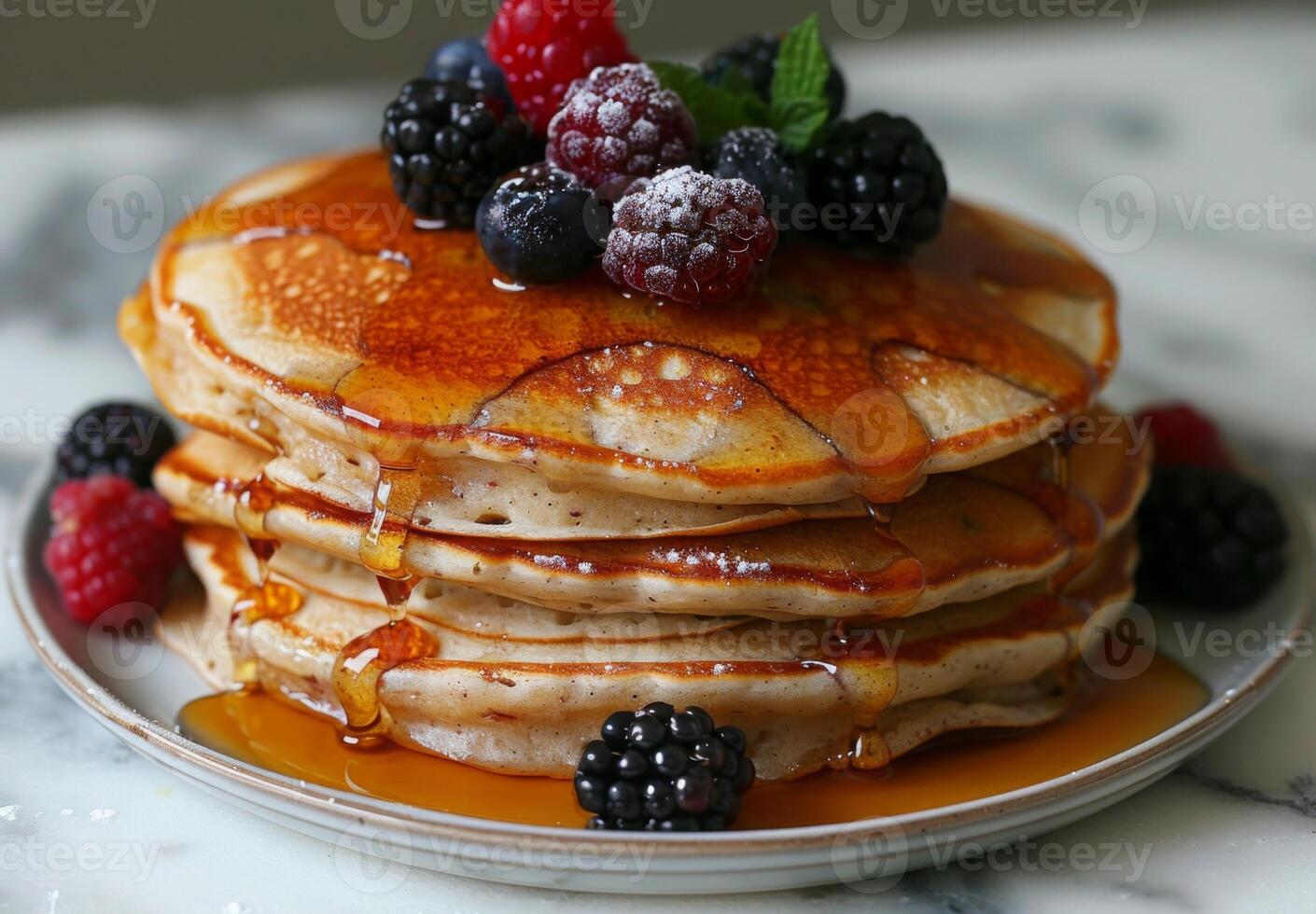 A stack of fluffy pancakes drizzled with maple syrup and topped with fresh berries photo