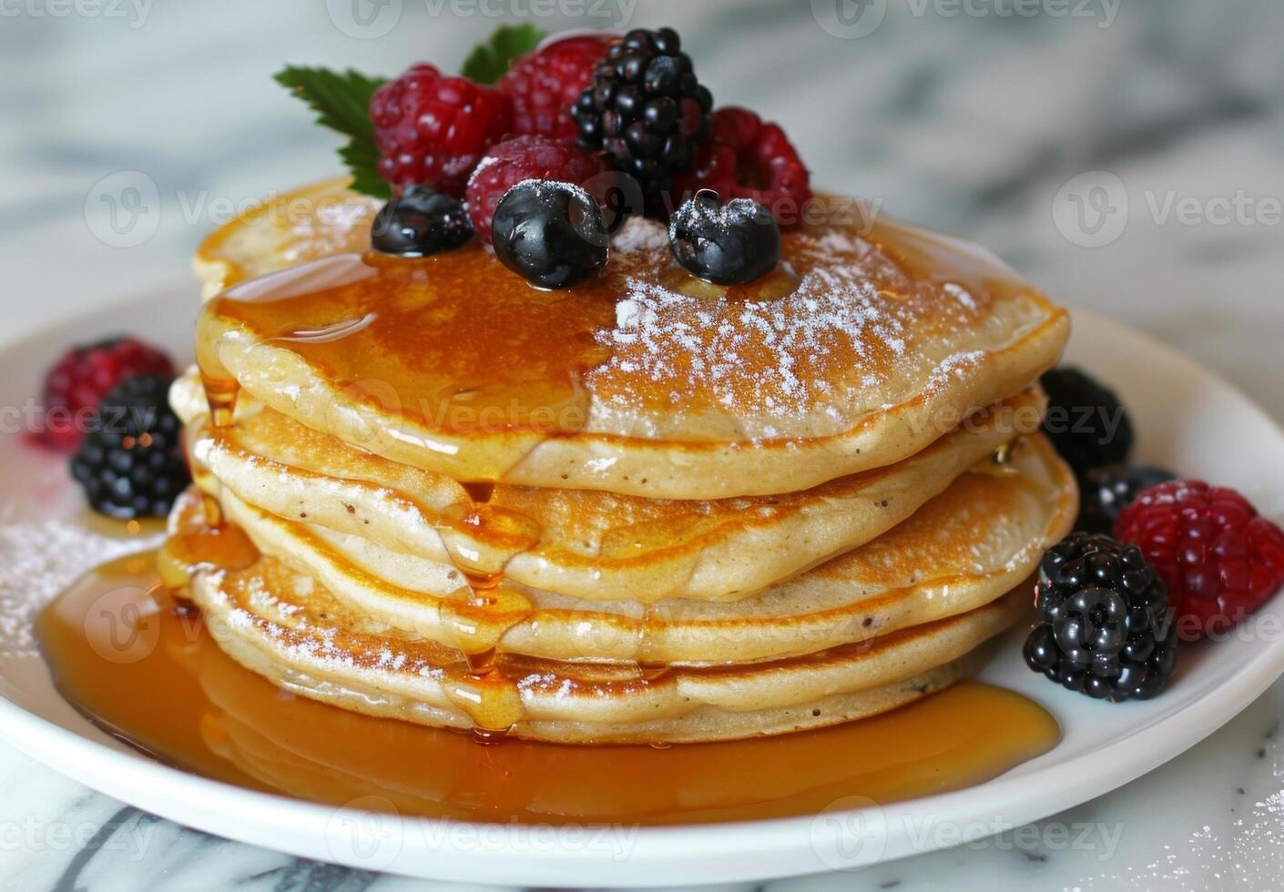 A stack of fluffy pancakes drizzled with maple syrup and topped with fresh berries photo