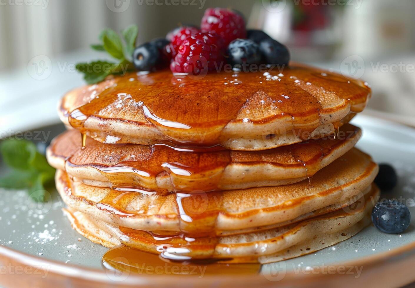 A stack of fluffy pancakes drizzled with maple syrup and topped with fresh berries photo